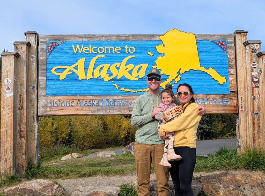 Picture of me and my family in front of the Alaska state sign. How I’m Working Just a Few Hours a Week This Summer (And Still Earning Full-Time Income)